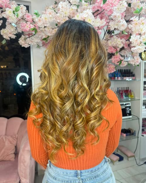 Cabello largo con balayage rubio miel y ondas marcadas, visto de espaldas