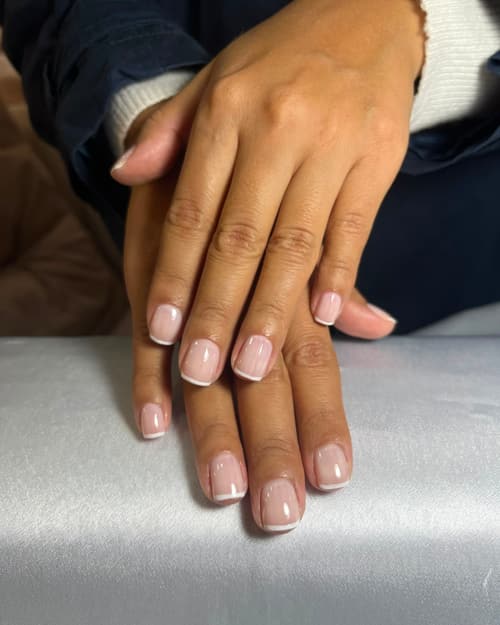 Manicura tradicional con francés blanco clásico sobre uñas naturales cortas