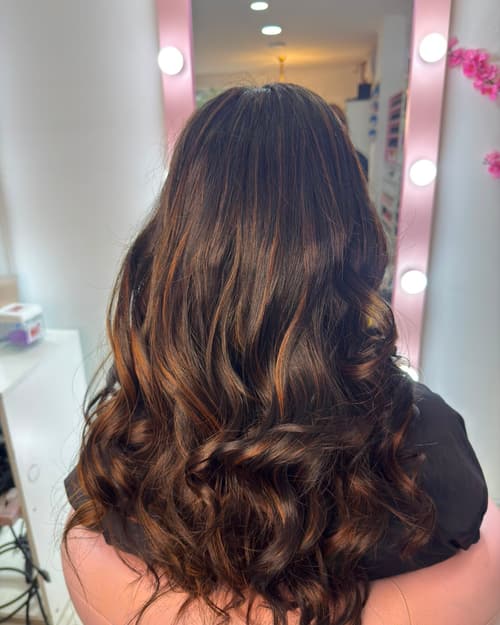 Cabello castaño oscuro con reflejos caramelo y ondas, visto de espaldas